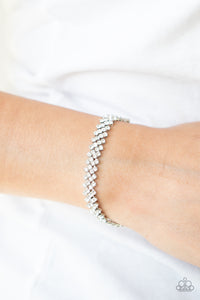 Featuring sleek silver fittings, dainty rows of glassy white rhinestones delicately slant across the wrist, coalescing into a timeless centerpiece. Features an adjustable clasp closure. 