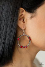 Load image into Gallery viewer, Featuring round, oval, and square cuts, a collection of fiery red rhinestones haphazardly adorn the front of a textured silver hoop, for a gritty-glamorous look. Earring attaches to standard fishhook fittings.
