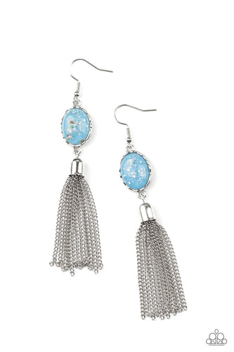 Flecks of shells are encased in a glassy Cerulean bead that is encased in a hammered silver frame. A silver chain tassel swings from the bottom of the iridescent frame, creating an ethereal display. Earring attaches to a standard fishhook fitting.
