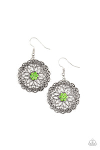 Overlapping silver petals fan out from a sparkly green rhinestone center inside a frilly ring of silver filigree, resulting in a whimsical floral frame. Earring attaches to a standard fishhook fitting. 