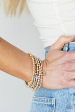 Load image into Gallery viewer, Infused with dainty gold star beads and shiny silver star charms, strands of gold and silver beaded stretchy bands stack across the wrist, creating a patriotic shimmer. 
