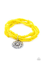 Load image into Gallery viewer, A shiny silver floral charm glides along stretchy strands of mismatched yellow seed beads, creating vibrant layers around the wrist. 
