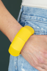 Painted in a sunny yellow finish, chunky geometric wooden beads are threaded along stretchy bands around the wrist for a colorful tropical inspired look. 