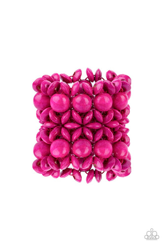 Brushed in a vibrant pink finish, an oversized collection of disc shaped and round wooden beads are threaded along ornately knotted woven stretchy bands around the wrist for a tropical inspired fashion. 