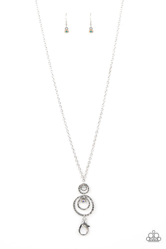Embellished with two iridescent rhinestones, hammered asymmetrical silver rings link at the bottom of a lengthened silver chain for an edgy look. A lobster clasp hangs from the bottom of the design to allow a name badge or other item to be attached. Features an adjustable clasp closure.