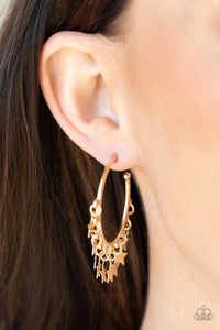 A shiny collection of gold star charms trickles from the bottom of a classic gold hoop, creating a stellar fringe. Earring attaches to a standard post fitting. Hoop measures approximately 1 1/4" in diameter. 