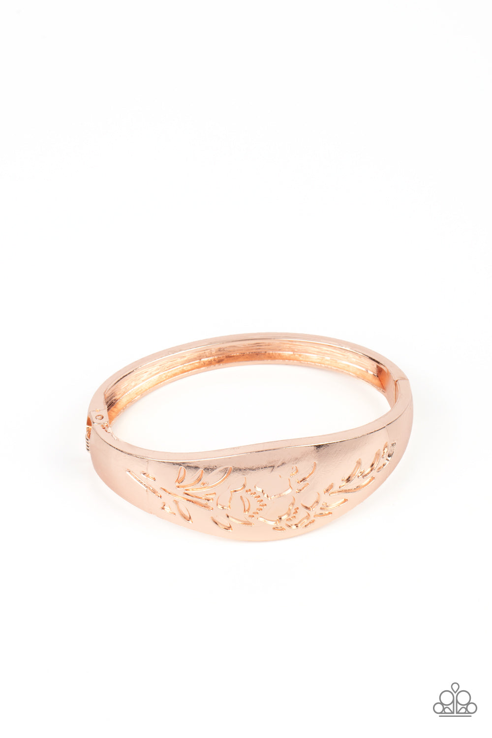 The front of a thick rose gold bangle-like bracelet is stamped in a leafy floral pattern, creating a whimsy centerpiece around the wrist. Features a hinged closure.