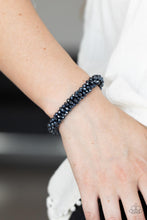 Load image into Gallery viewer, Sparkling with dramatic brilliance, a collection of dainty faceted blue beads are threaded along a woven stretchy band creating a stunning statement around the wrist.
