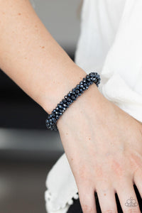 Sparkling with dramatic brilliance, a collection of dainty faceted blue beads are threaded along a woven stretchy band creating a stunning statement around the wrist.