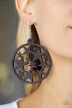 Load image into Gallery viewer, An oversized round brown wooden frame is filled with a cosmos of cut-out brown stars creating a whimsical statement. Earring attaches to a standard fishhook fitting.
