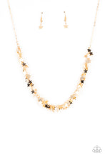 Load image into Gallery viewer, A glistening collection of dainty gold star charms delicately cluster on a classic gold chain, creating a stellar fringe below the collar. Features an adjustable clasp closure
