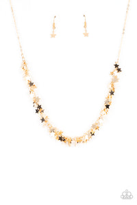 A glistening collection of dainty gold star charms delicately cluster on a classic gold chain, creating a stellar fringe below the collar. Features an adjustable clasp closure