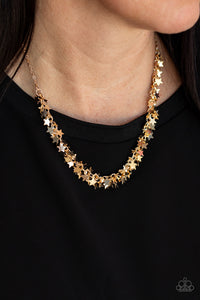 A glistening collection of dainty gold star charms delicately cluster on a classic gold chain, creating a stellar fringe below the collar. Features an adjustable clasp closure