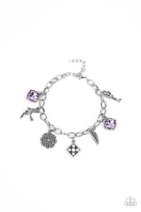 Sparkling purple gems, a floral medallion, a bird in flight, and a fluttering feather dangle from a delicate silver chain as they coalesce into a whimsical charm bracelet. Features an adjustable clasp closure. 