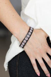 Featuring dainty brown centers, a casual row of white flowers is stitched across the front of a skinny brown leather band for a seasonal look. Features an adjustable snap closure.