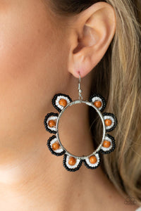 Infused with earthy brown stone bead centers, rows of black and white seed beads are threaded along dainty wires along the outside of a shiny silver hoop for a vivacious floral look. Earring attaches to a standard fishhook fitting. 