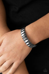 Polished in a high sheen finish, a crinkled gunmetal cuff delicately curls around the wrist for an intense industrial look.  Sold as one individual bracelet.