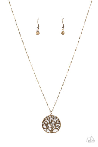Featuring topaz rhinestone adorned leaves, dainty brass branches climb an asymmetrical brass frame, creating a whimsical tree pendant at the bottom of a dainty brass chain. Features an adjustable clasp closure.