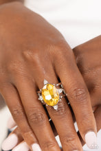 Load image into Gallery viewer, Featuring silver prongs and glassy white rhinestones, an oversized yellow oval gem sits atop two glistening silver bands for a sensational finish. Features a stretchy band for a flexible fit.
