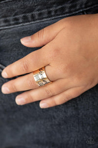 The front of a thick gold band is stamped in the phrase, "Dream out loud," creating an inspirational centerpiece across the finger. Features a stretchy band for a flexible fit.