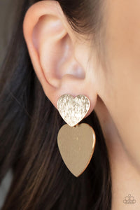 Delicately scratched in shimmer, a dainty gold heart frame delicately links with a larger gold heart frame for a flirtatiously layered look. Earring attaches to a standard post earring.