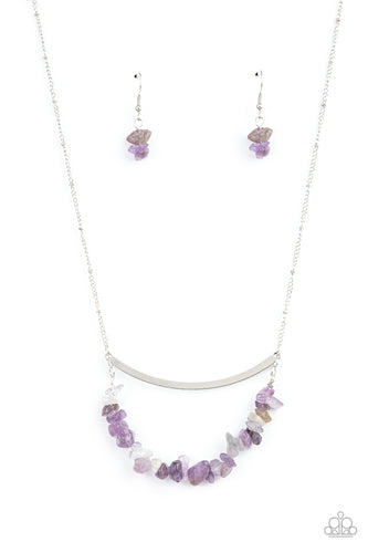 A row of raw cut amethyst rocks are threaded along a dainty wire that bows at the bottom of a curved silver bar, creating an earthy pendant. The colorfully stacked frame swings from the bottom of a lengthened silver satellite chain for a glamorously grounding effect. Features an adjustable clasp closure.