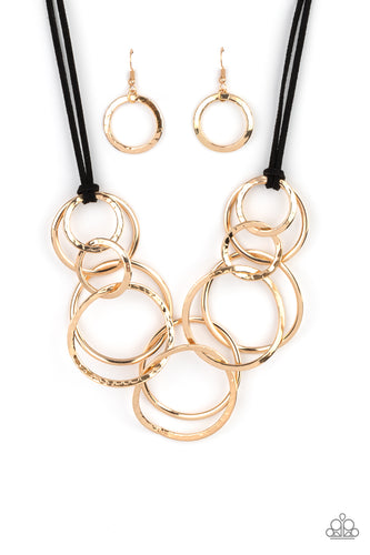 Black suede cords knot around a mismatched assortment of hammered gold rings that interlock below the collar, creating two rows of dizzying texture. Features an adjustable clasp closure.