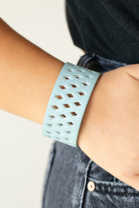 A wide blue leather band is filled with patterned rows of small diamond-shaped cutouts giving the illusion of diamonds floating across the wrist in a whimsical fashion. Features an adjustable snap closure.