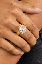 Load image into Gallery viewer, An oversized trilliant cut white rhinestone encased in a sparkling rhinestone-encrusted gold frame steals the spotlight and creates an eye-catching stunner atop the finger. Features a dainty stretchy band for a flexible fit. &lt;/P&gt;  &lt;br&gt;Featured inside The Preview at GLOW! 
