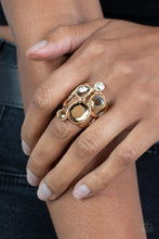 Load image into Gallery viewer, A collection of sparkling champagne-colored gems in varying sizes, accented by a single white rhinestone, forms an asymmetrical cluster atop the finger. Set in sleek gold frames over airy gold bands, the brilliant gems demand full attention. Features a stretchy band for a flexible fit. 
