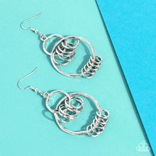 Load image into Gallery viewer, An antiqued collection of dainty silver rings swings from the bottoms of hammered silver hoops that interconnect into an edgy lure. Earring attaches to a standard fishhook fitting.
