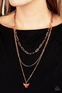 Dotted with a dainty white rhinestone, a decoratively layered shiny copper butterfly swings from the bottom of a display of mismatched shiny copper chains for a whimsically fluttering fashion. Features an adjustable clasp closure. 