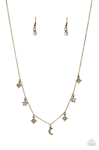 Dotted with dainty white rhinestones, a stellar collection of brass moon and star charms swing from a dainty brass chain below the collar, creating a cosmic fringe. Features an adjustable clasp closure.