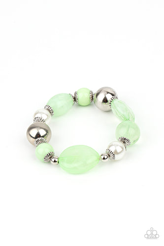 A lavish assortment of white pearls, silver accents, and glassy and acrylic Green Ash beads are threaded along a stretchy band around the wrist for a refreshing pop of color.