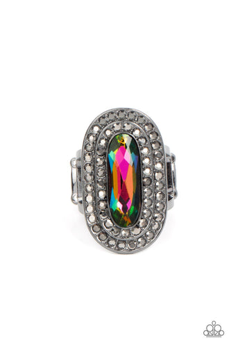 An elongated sparkling oil spill gem is nestled inside a linear hematite frame created by double rows of dainty smoky rhinestones. The faceted gem creates a glamorously edgy effect atop the finger. Features a stretchy band for a flexible fit.  Sold as one individual ring.  Life of the Party December 2021 Exclusive item.
