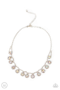 A dainty strand of glittery white rhinestones encircle solitaire iridescent rhinestones around the neck, creating a glitzy fringe. Features an adjustable clasp closure.