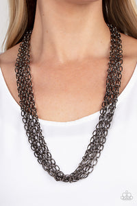 Layer after layer of edgy gunmetal chains drape across the chest, creating an intense industrial display. Features an adjustable clasp closure.