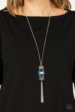 Load image into Gallery viewer, A sparkly collection of mismatched smoky, blue, and hematite rectangular gems stack at the bottom of a lengthened silver chain, creating a glamorous pendant. A dainty silver chain tassel swings from the bottom, adding glamorous movement to the modern display. Features an adjustable clasp closure.
