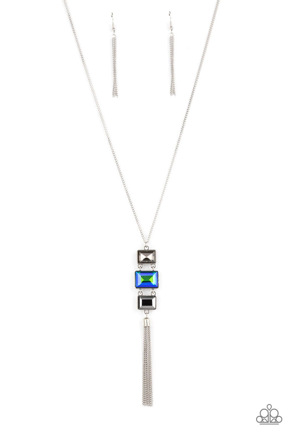 A sparkly collection of mismatched smoky, blue, and hematite rectangular gems stack at the bottom of a lengthened silver chain, creating a glamorous pendant. A dainty silver chain tassel swings from the bottom, adding glamorous movement to the modern display. Features an adjustable clasp closure.