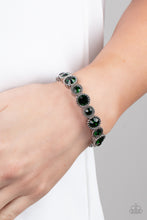 Load image into Gallery viewer, Sparkling green gems are encased in studded silver frames. Varying in size, smaller gems alternate with larger gems along stretchy bands around the wrist for a dramatic look. 
