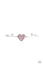 Load image into Gallery viewer, Brimming with dainty emerald-cut pink rhinestones, a simple silver heart frame sits atop a classic silver bar curved into a simple cuff bracelet for a whimsical display across the wrist. 
