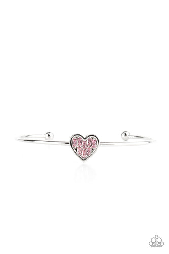 Brimming with dainty emerald-cut pink rhinestones, a simple silver heart frame sits atop a classic silver bar curved into a simple cuff bracelet for a whimsical display across the wrist. 