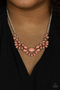 Teardrop Pale Rosette beads fan out from the bottoms of solitaire white rhinestones as they link below the collar, creating whimsically stacked frames. Featuring an oval center, oversized teardrop beads flare out from the centermost frame for a flirtatiously floral finish. Features an adjustable clasp closure. 