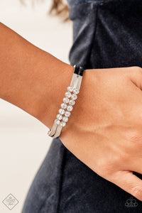 Stacked layers of brilliant white rhinestones give way to double layers of sleek silver frames that feature a subtle wave, creating a dramatically modern design around the wrist. Features a hinged closure.  Sold as one individual bracelet.