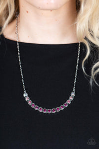 Encased in studded silver fittings, a glittery ombré of pink rhinestones delicately bows below the collar, creating an enchanting pop of color. Features an adjustable clasp closure.