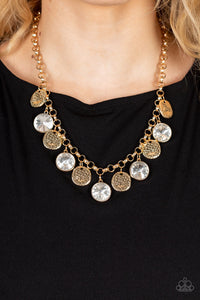 A blinding collection of hammered gold discs and oversized white gems swing from the bottom of a bold gold chain, creating noise-making sparkle below the collar. Features an adjustable clasp closure