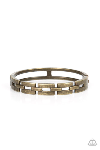 An antiqued row of rectangular brass links boldly interlock across the top of the wrist, coalescing into an edgy bangle-like bracelet. Features a hinged closure.