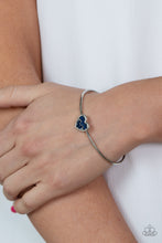 Load image into Gallery viewer, A studded silver heart is encrusted in emerald cut blue rhinestones, creating a flirtatious centerpiece atop a dainty silver cuff.
