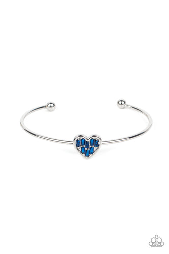 A studded silver heart is encrusted in emerald cut blue rhinestones, creating a flirtatious centerpiece atop a dainty silver cuff.
