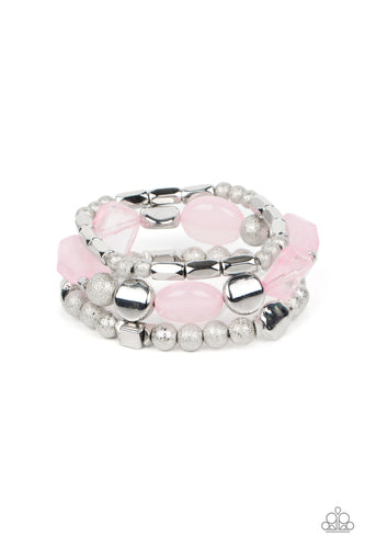 Infused with enchanting pops of Pale Rosette crystal-like and glassy accents, a mismatched assortment of hammered, cube, and faceted silver beads are threaded along stretchy bands around the wrist, creating shimmery layers.